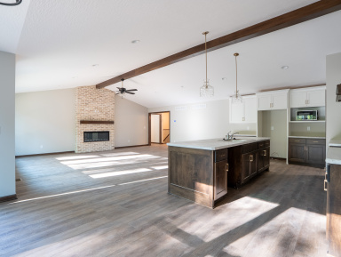 Kitchen with a fireplace, wooden floors and a wood beam on the ceiling