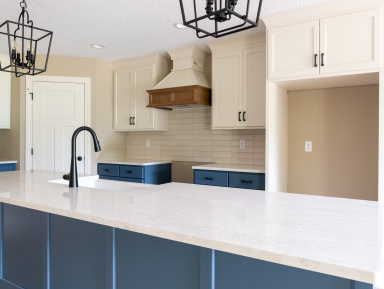 Capstone custom kitchen with blue counter top and white cabinets